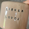 A pair of small mugs with words in Lithuanian