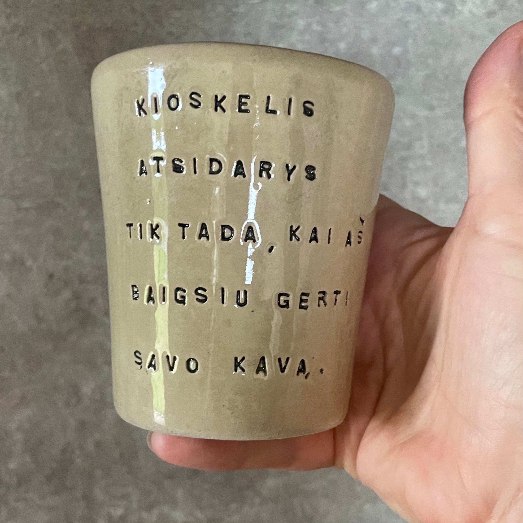 Puodelis su smagiu užrašu apie kavą ir kioskelį