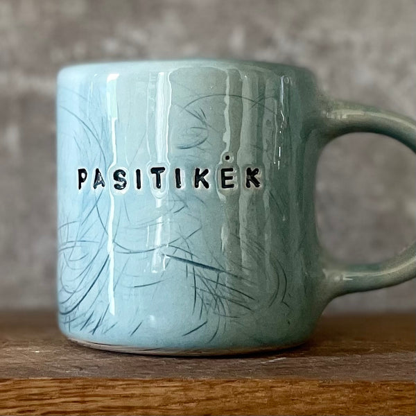 Blue ceramic mug with word PASITIKĖK