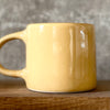 Yellow coffee mug with saying about happiness
