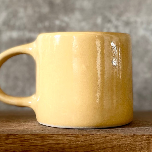 Yellow coffee mug with saying about happiness