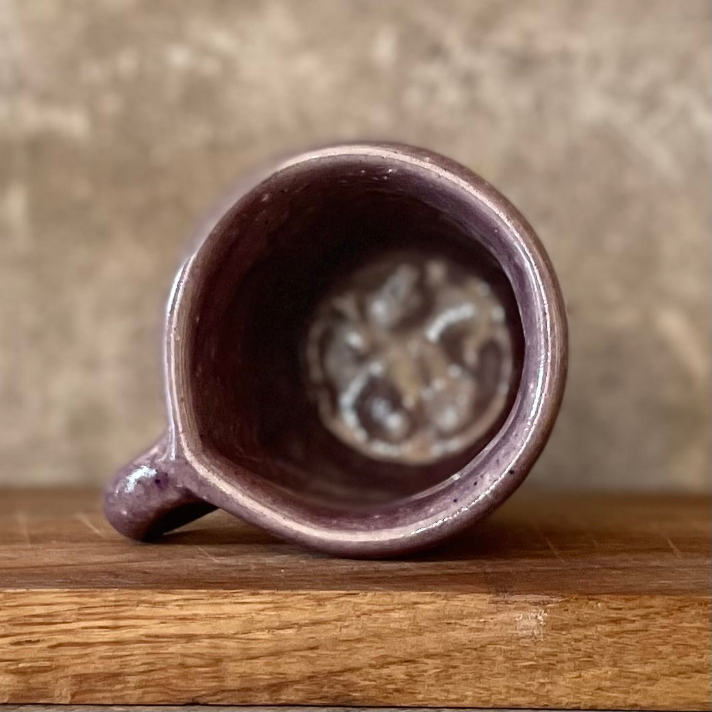 Small purple mug with words in Lithuanian