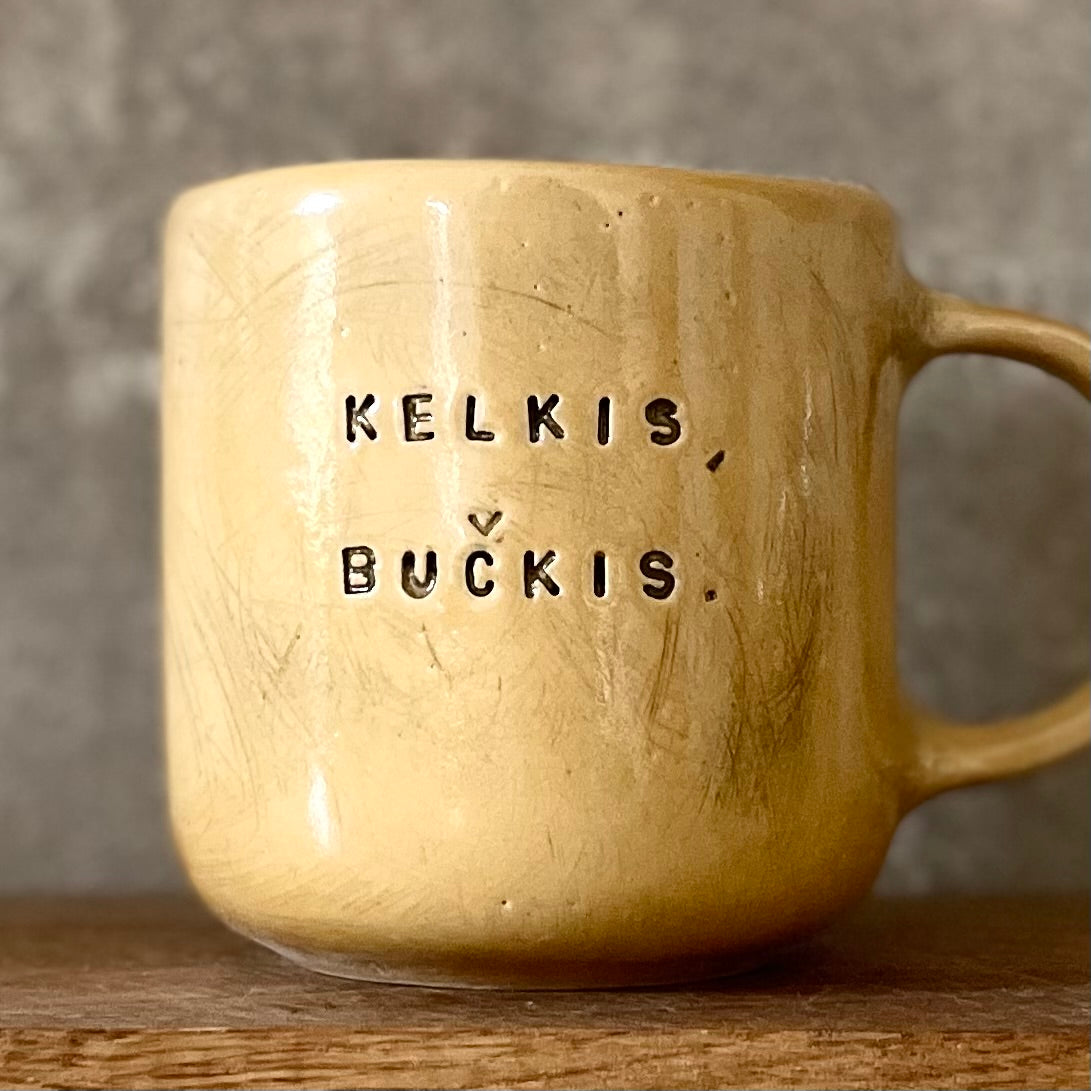 Big yellow mug with saying in Lithuanian