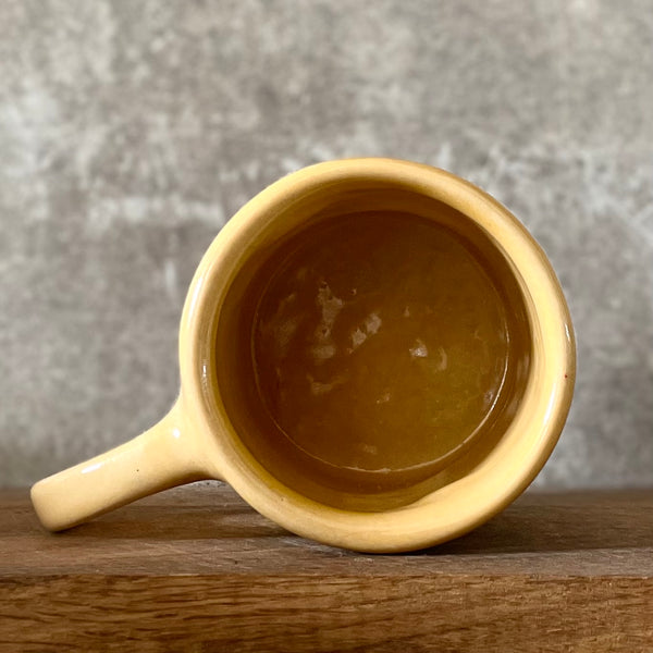 Yellow coffee mug with saying about happiness