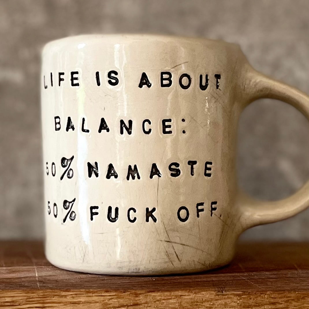 Ceramic mug with saying about balance with handle