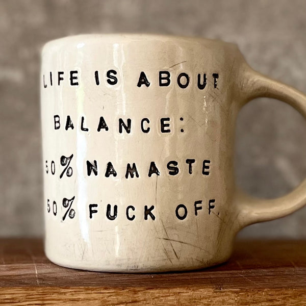 Ceramic mug with saying about balance with handle