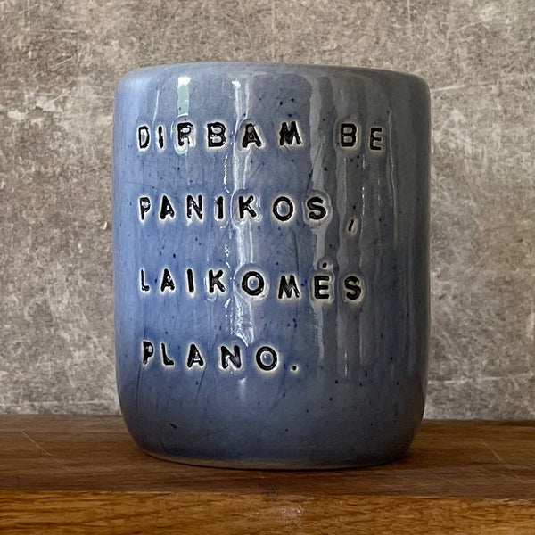Blue ceramic mug without handle with words about work
