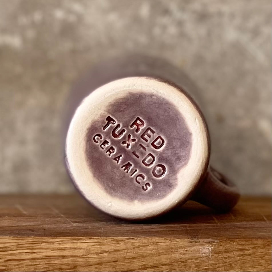 Small purple mug with words in Lithuanian