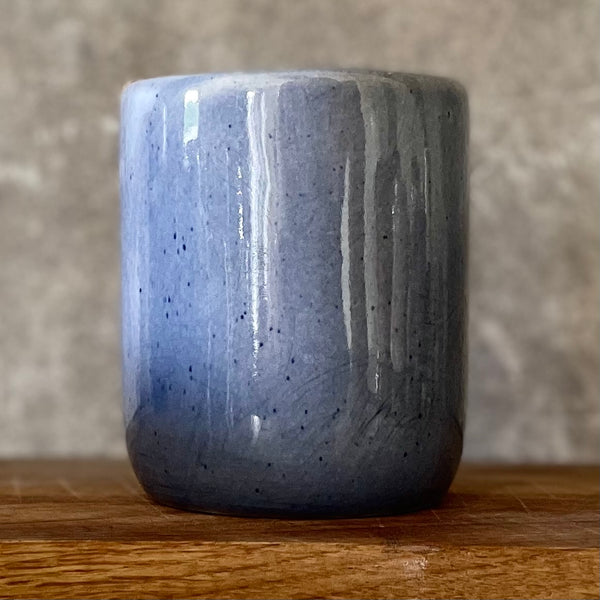 Blue ceramic mug without handle with words about work