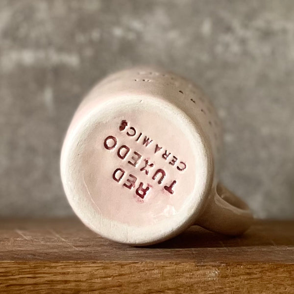 Small pink mug with words in Lithuanian