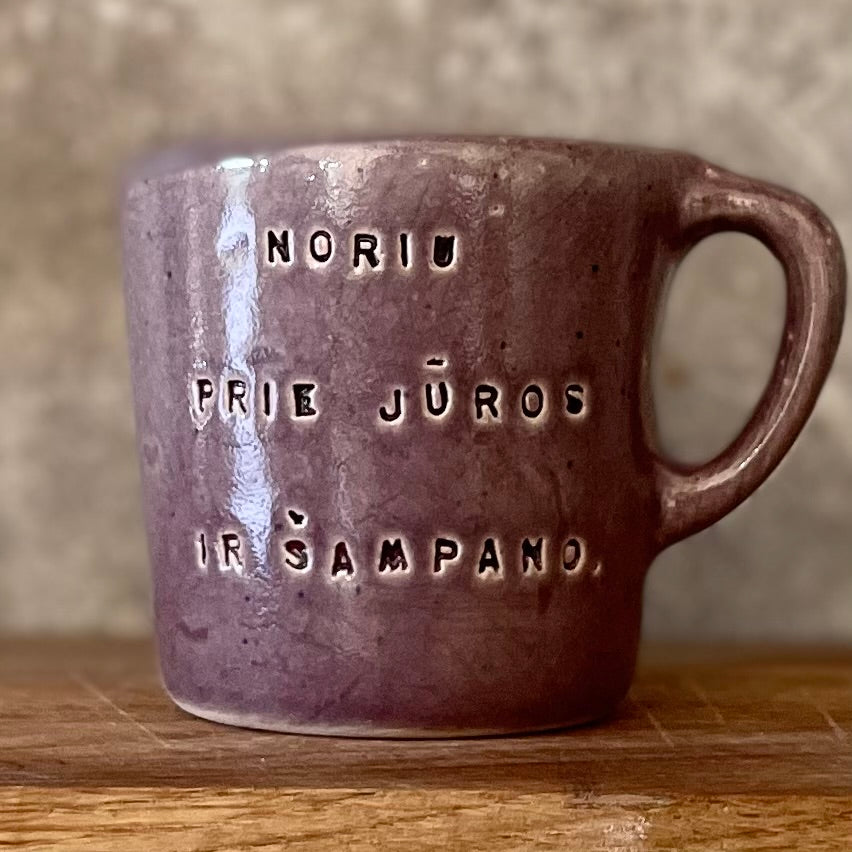 Small purple mug with words in Lithuanian