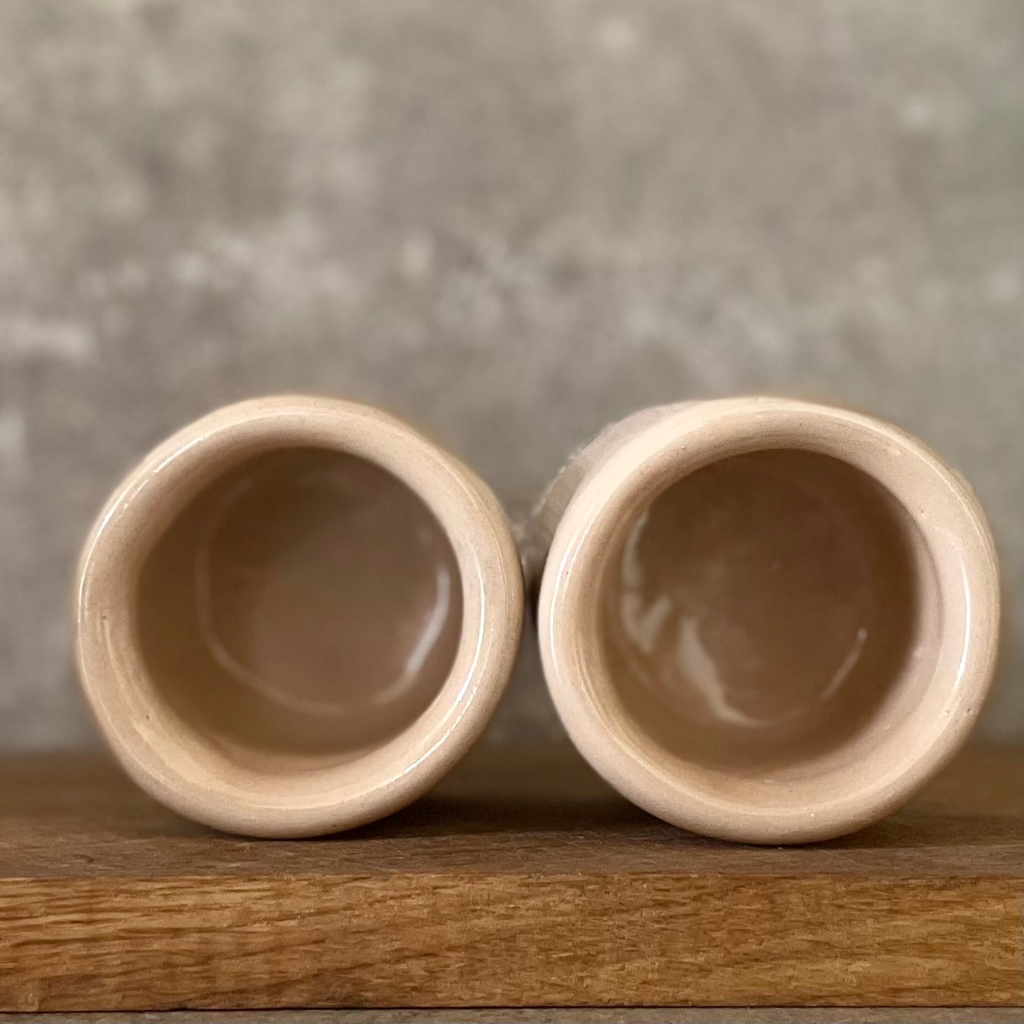 A pair of small mugs with words in Lithuanian