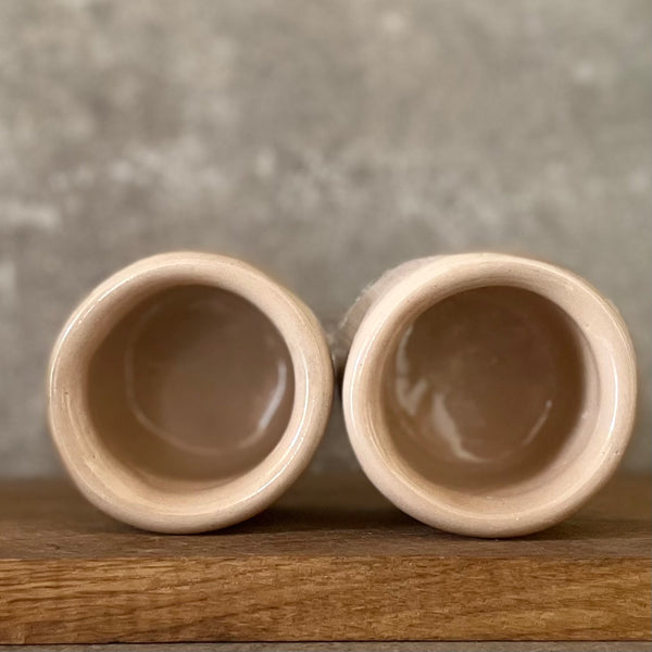 A pair of small mugs with words in Lithuanian