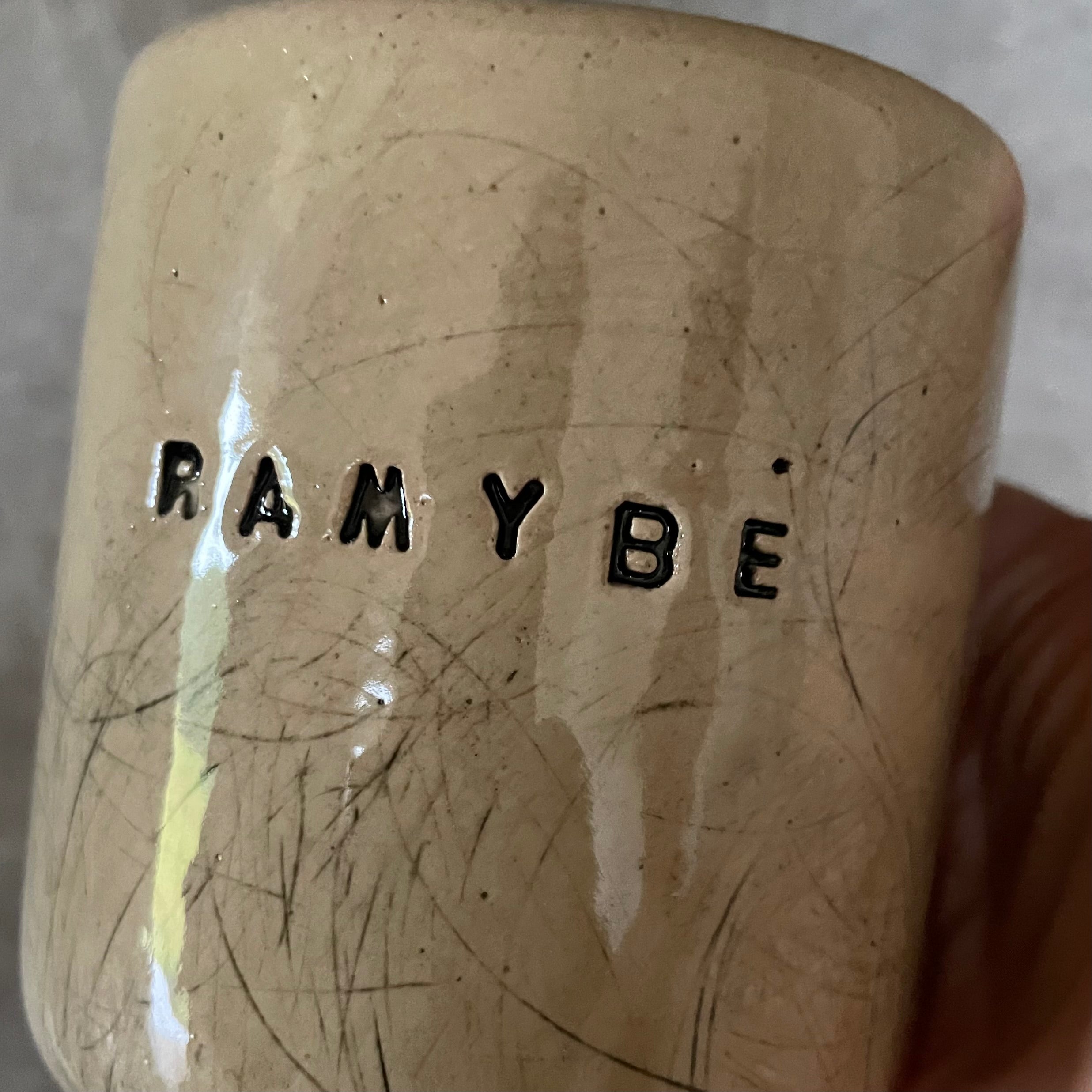 Beige tumbler mug with word RAMYBE