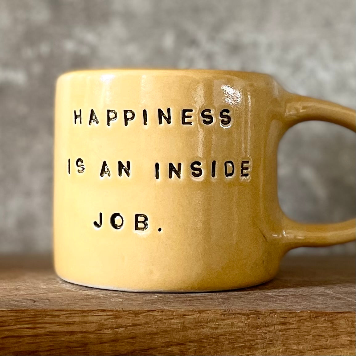 Yellow coffee mug with saying about happiness