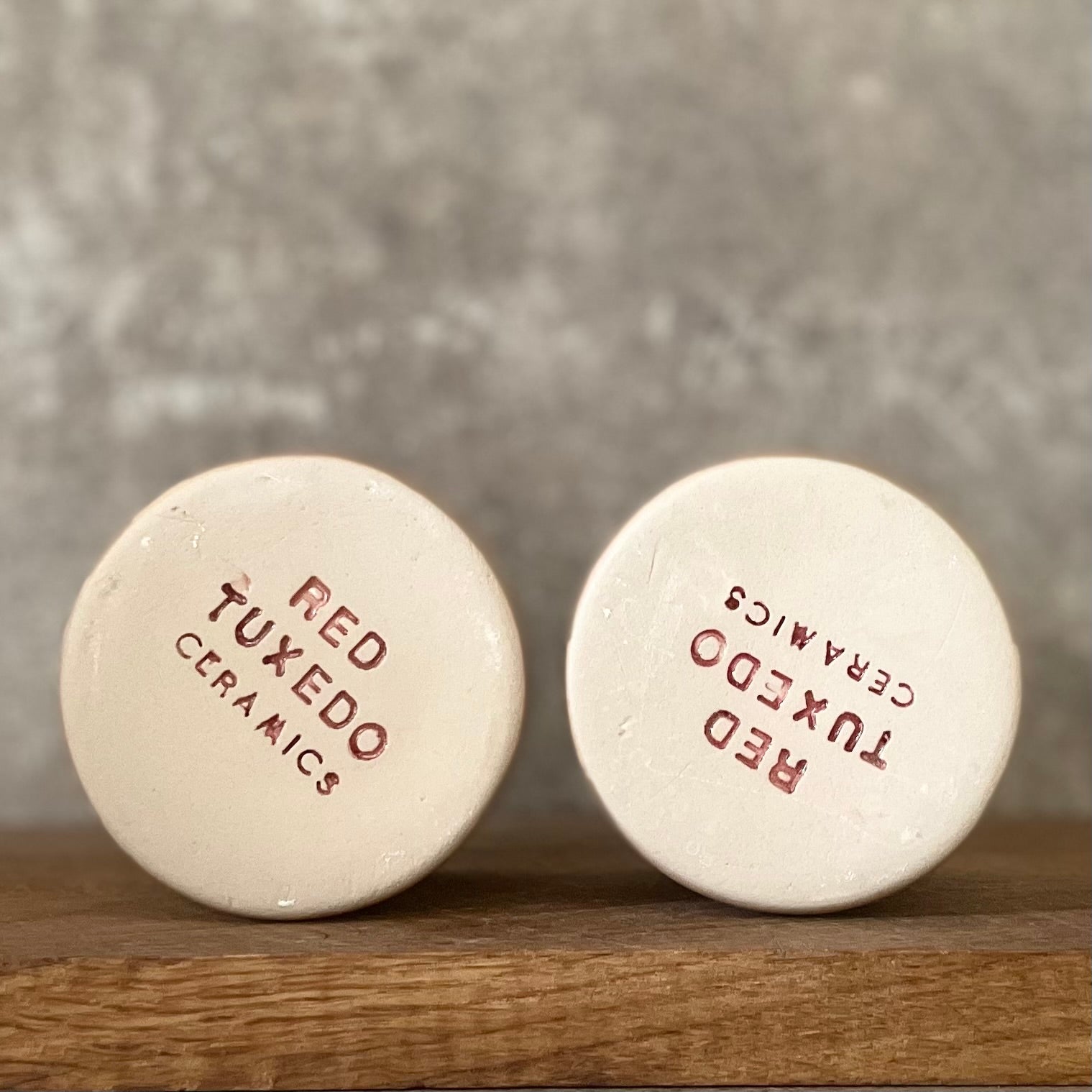 A pair of small mugs with words in Lithuanian
