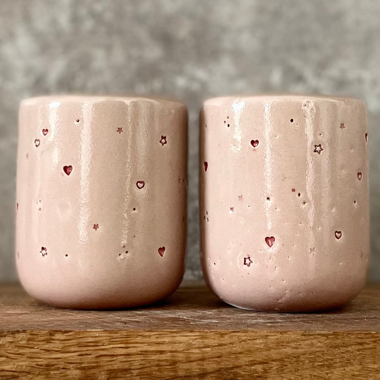 Du maži rožiniai puodeliai su širdelėmis