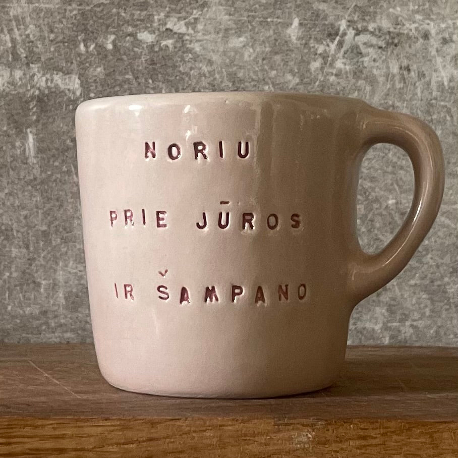 Small pink mug with words in Lithuanian