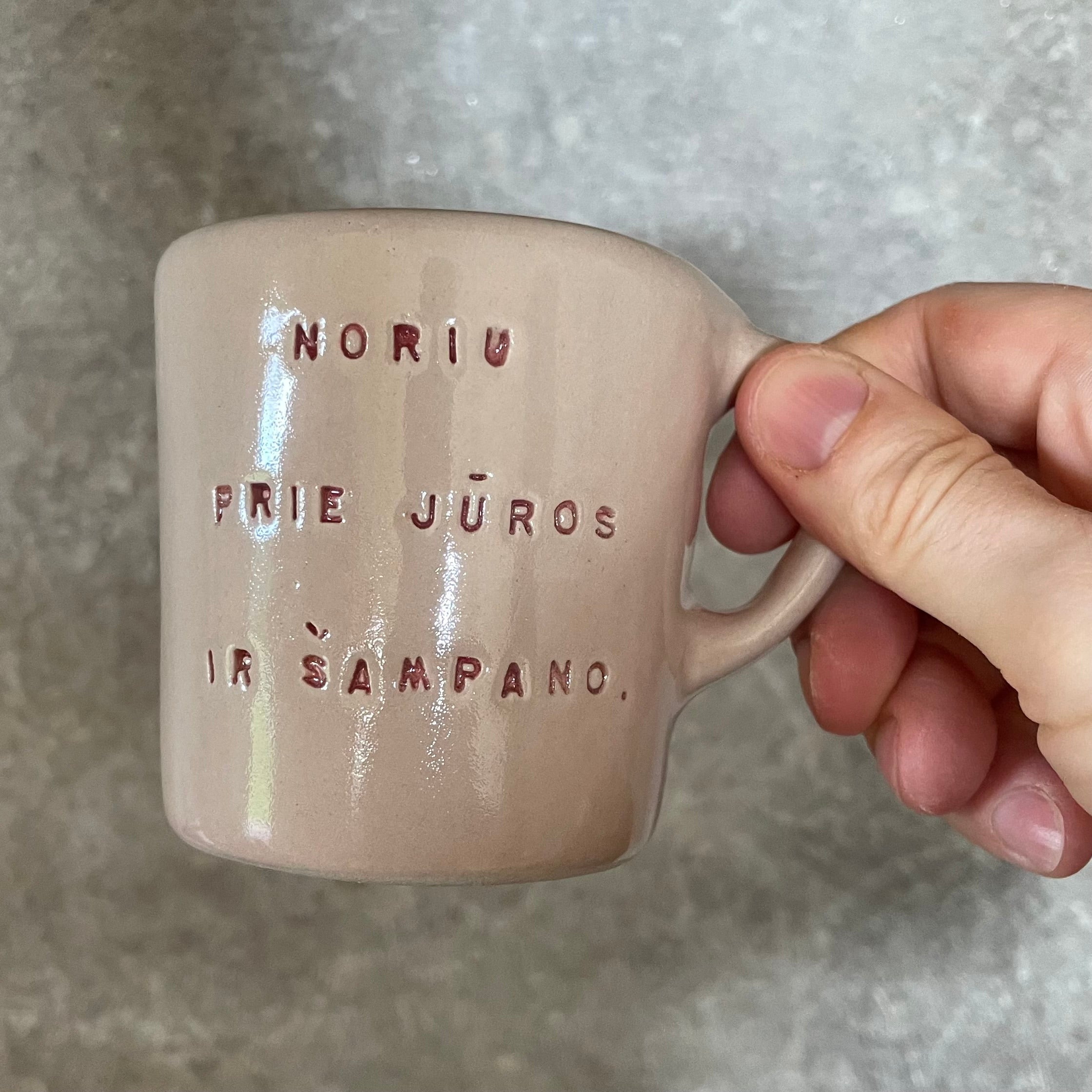 Small pink mug with words in Lithuanian
