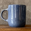 Blue mug with words in Lithuanian