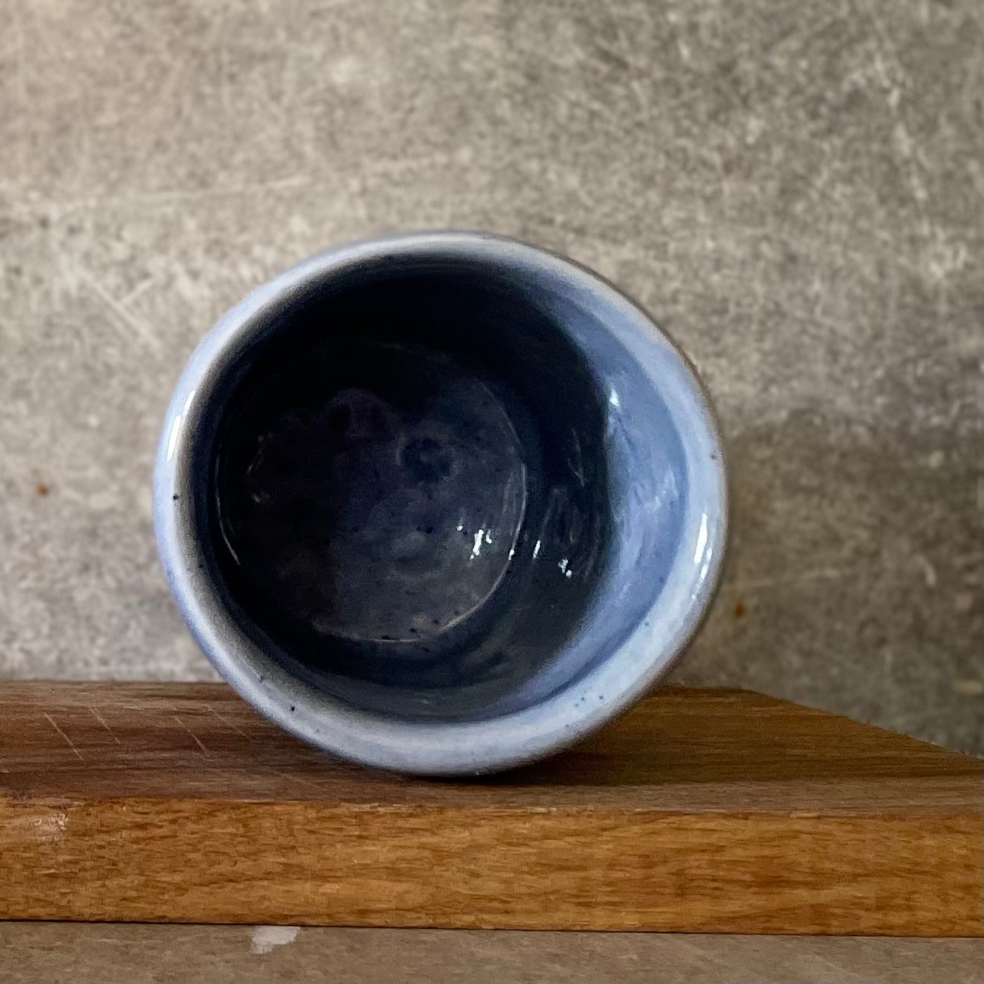 Blue ceramic mug without handle with words about work