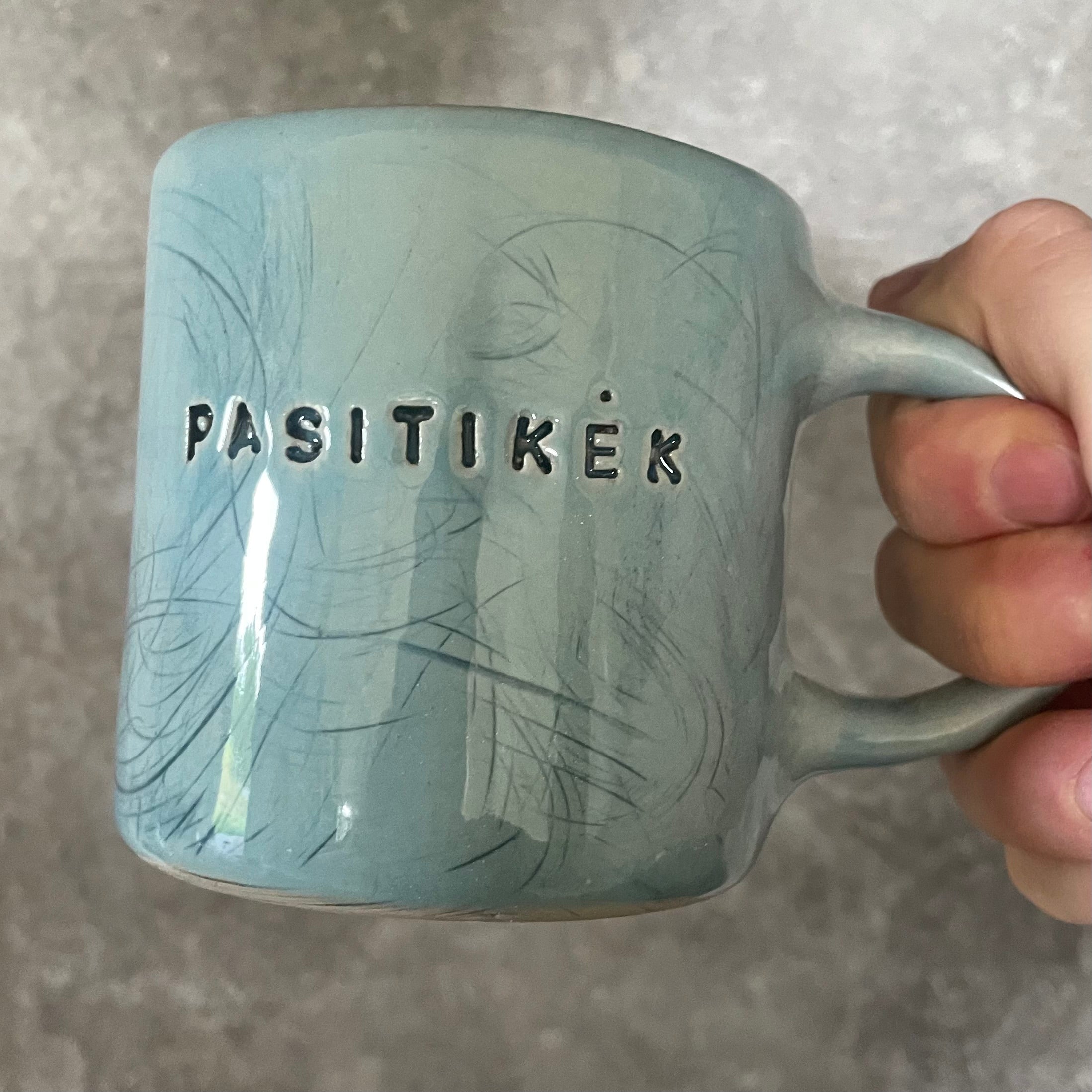Blue ceramic mug with word PASITIKĖK