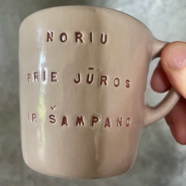 Small pink mug with words in Lithuanian