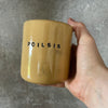 Yellow tumbler mug with word in Lithuanian POILSIS