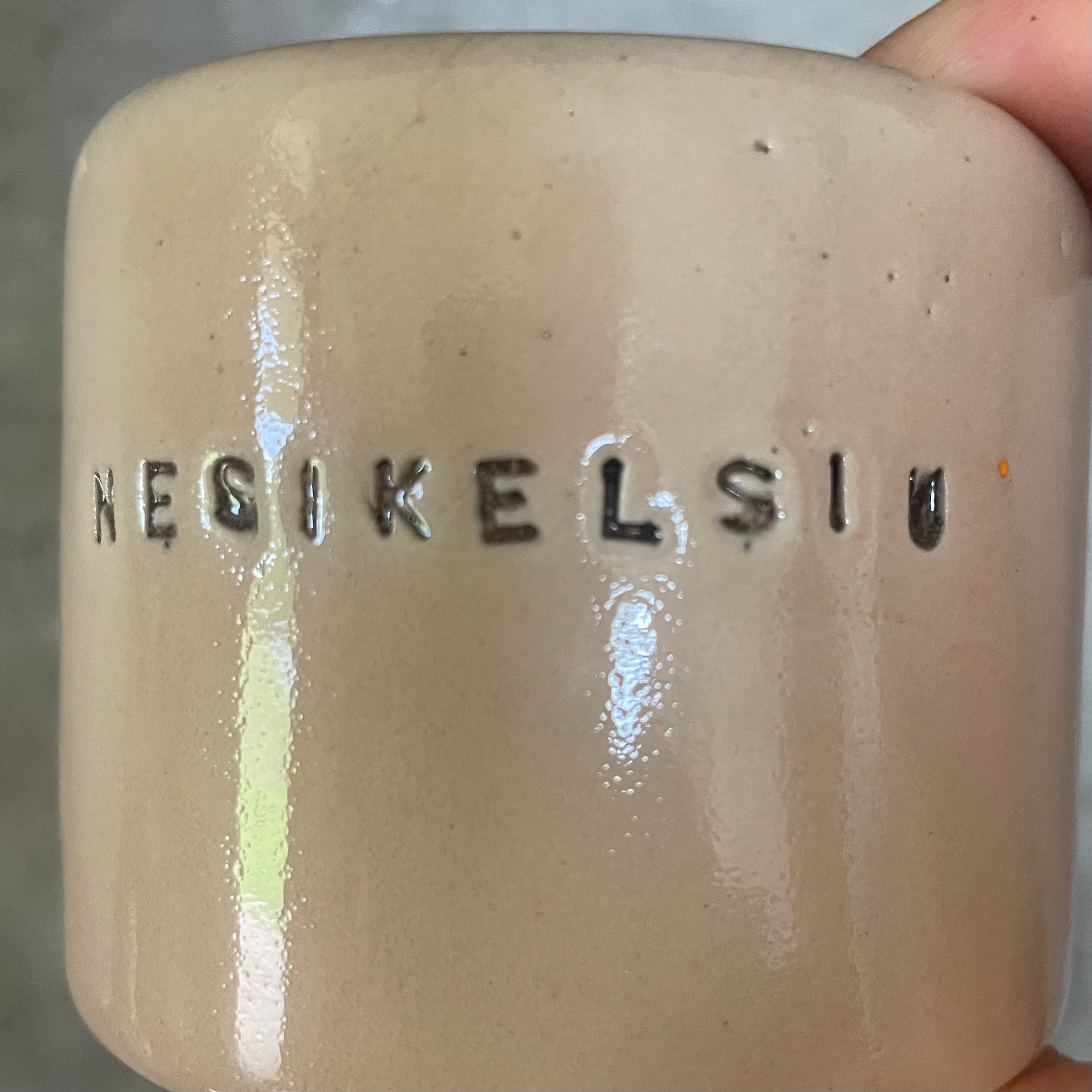 A pair of small mugs with words in Lithuanian