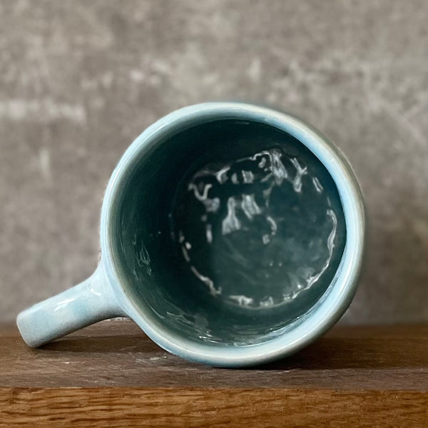 Blue ceramic mug with word PASITIKĖK