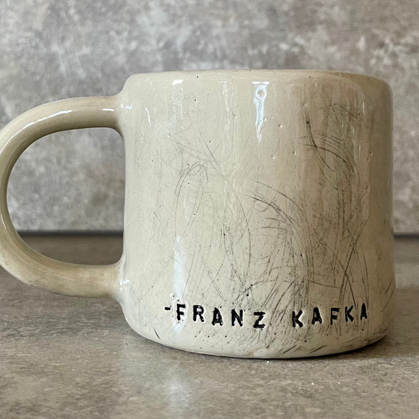 Keramikinis puodelis su Kafkos citata