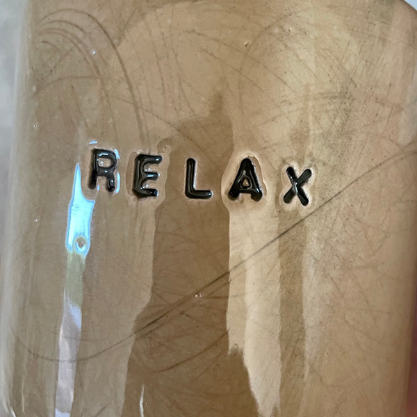 A pair of coffee mugs RELAX
