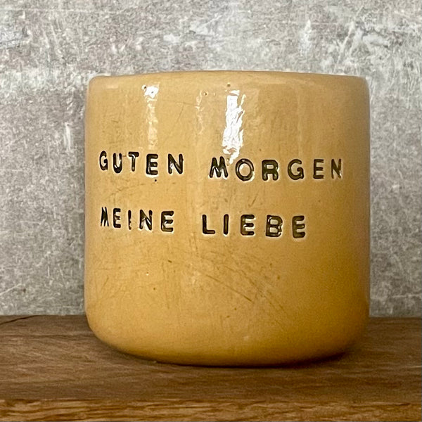 Yellow tumbler mug with words in German