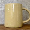 Yellowish coffee mug with funny saying