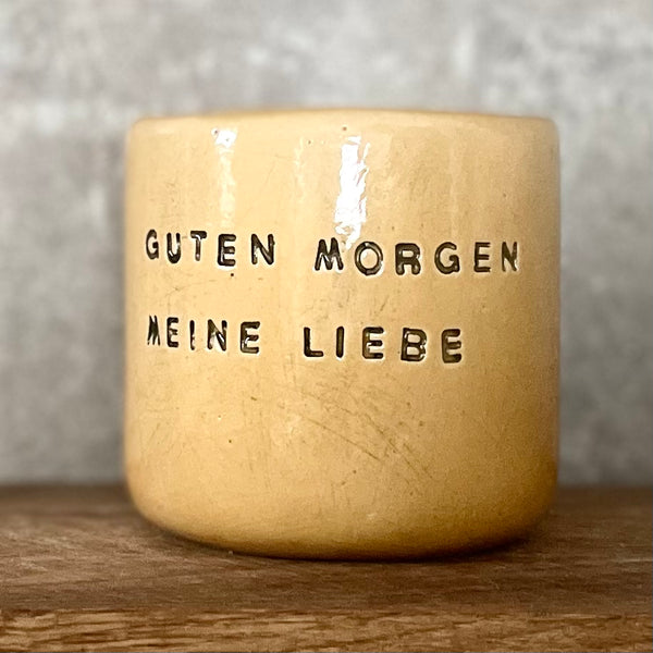 Yellow tumbler mug with words in German
