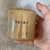 A pair of coffee mugs RELAX
