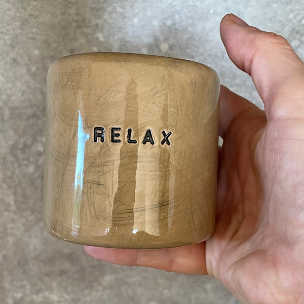 A pair of coffee mugs RELAX