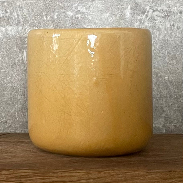 Yellow tumbler mug with words in German