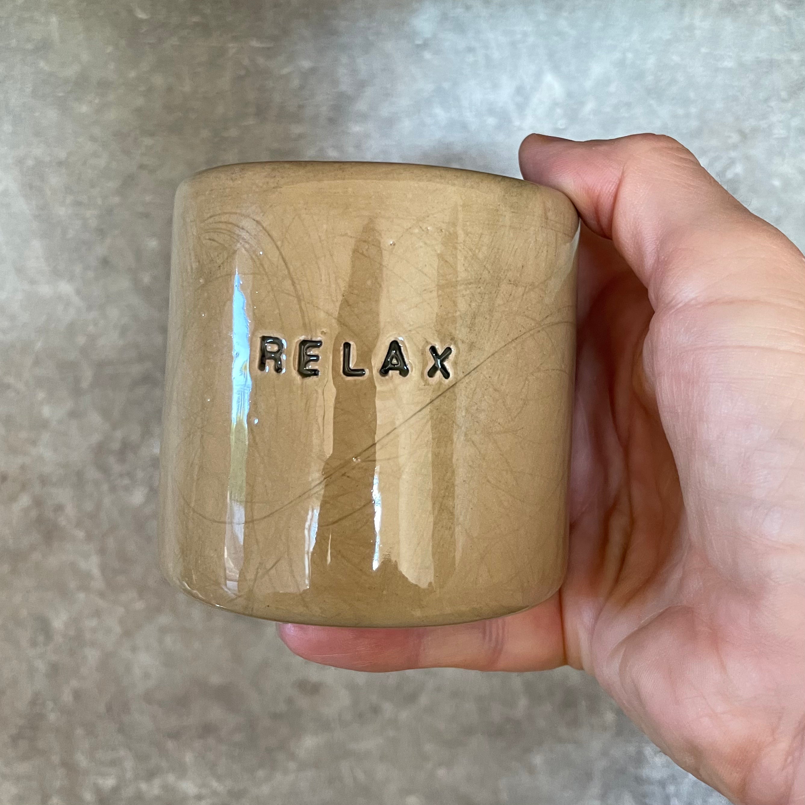 A pair of coffee mugs RELAX