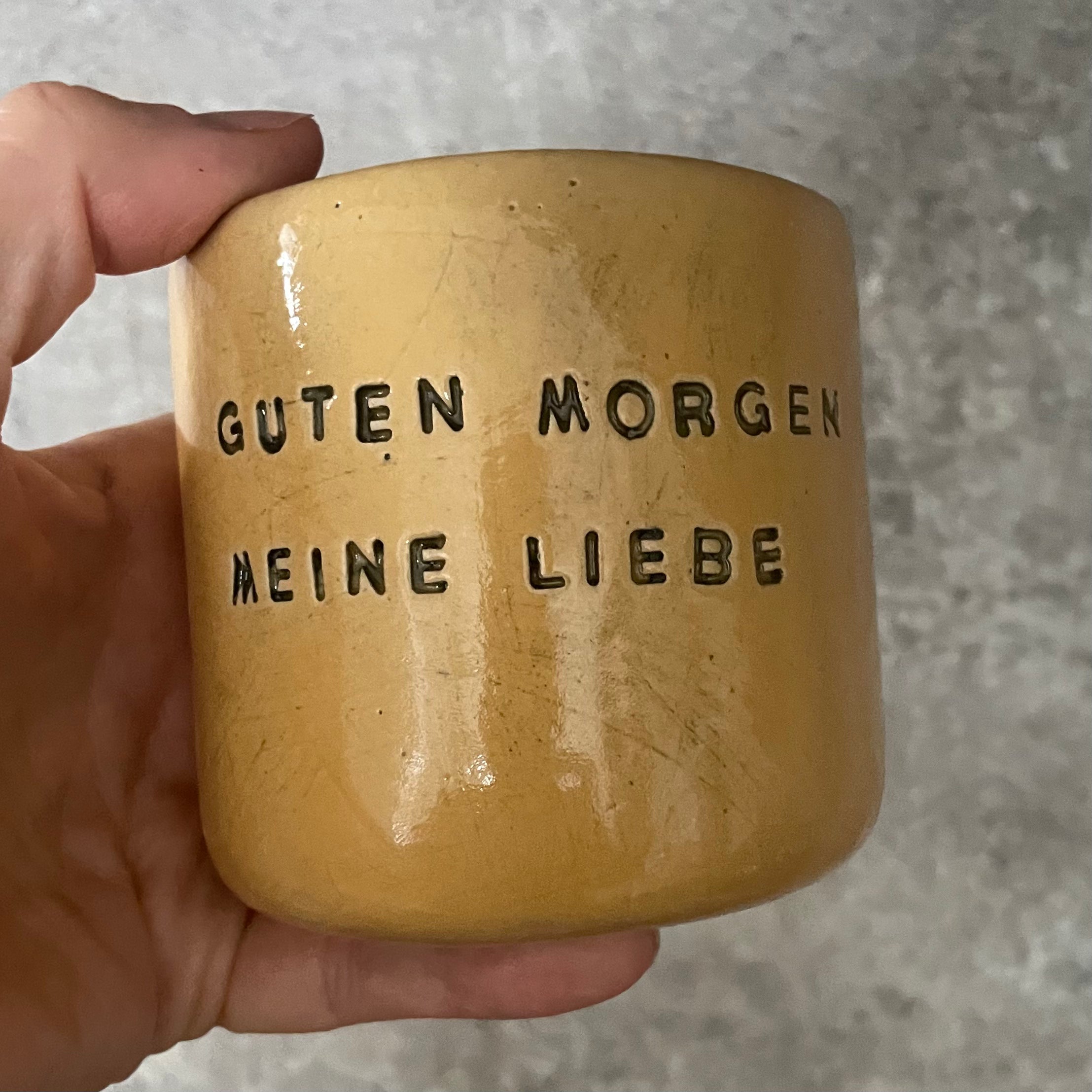 Yellow tumbler mug with words in German