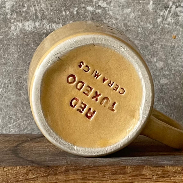 Yellow cup with saying "LABAS RYTAS"