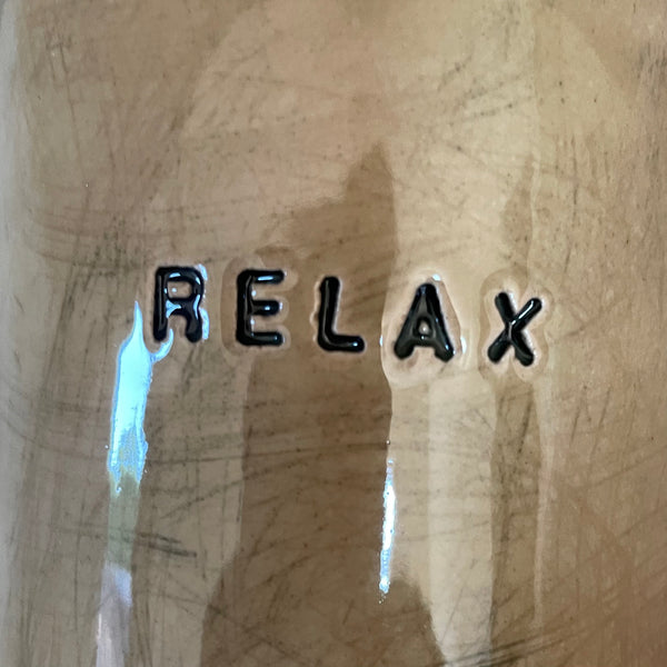 A pair of coffee mugs RELAX