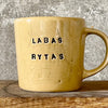 Yellow cup with saying "LABAS RYTAS"