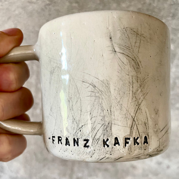 Keramikinis puodelis su Kafkos citata