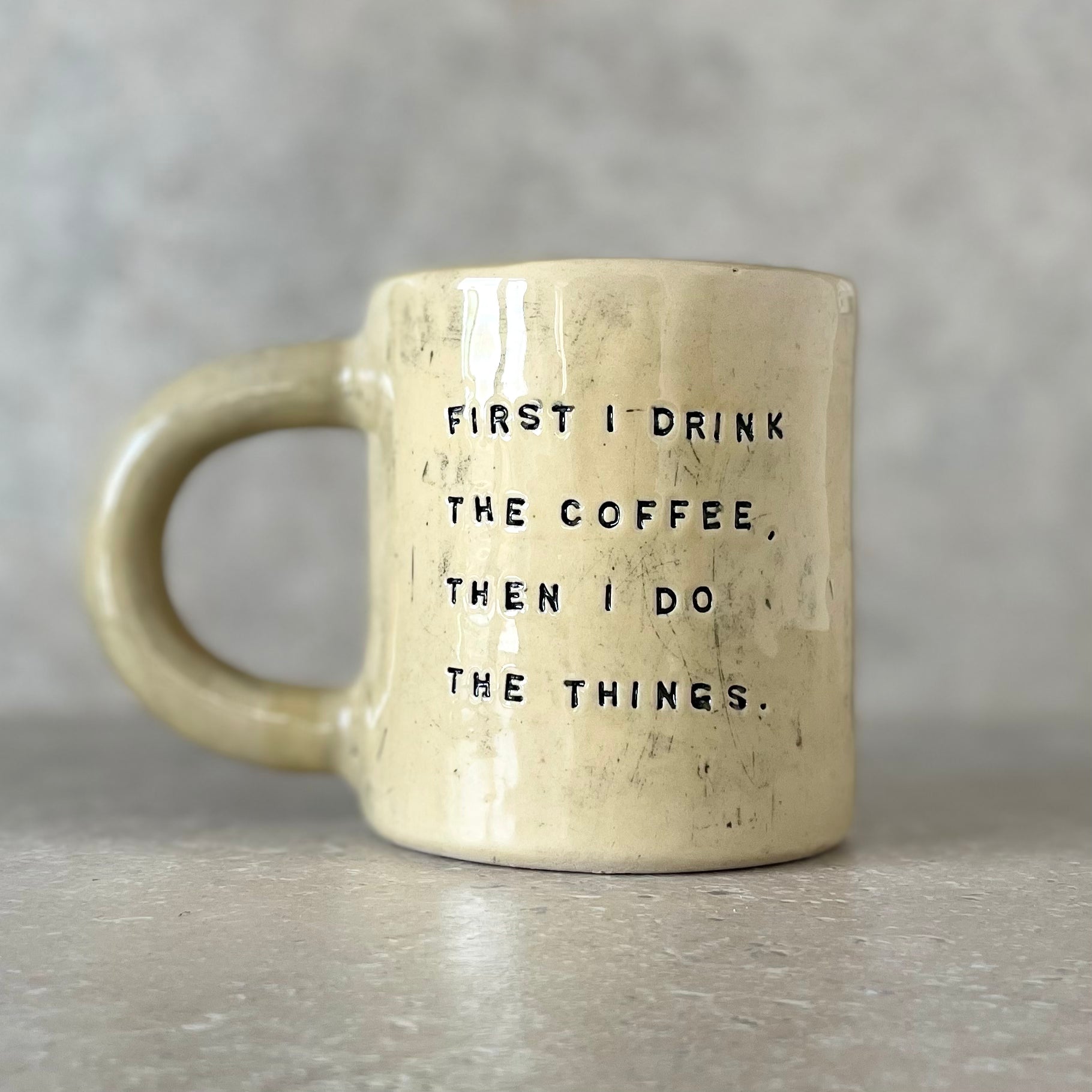 Yellow ceramic mug with saying about coffee