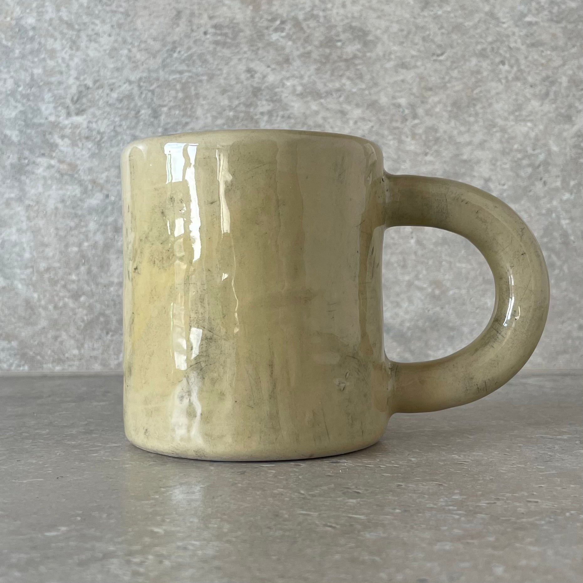 Yellow ceramic mug with saying about coffee