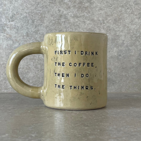 Yellow ceramic mug with saying about coffee
