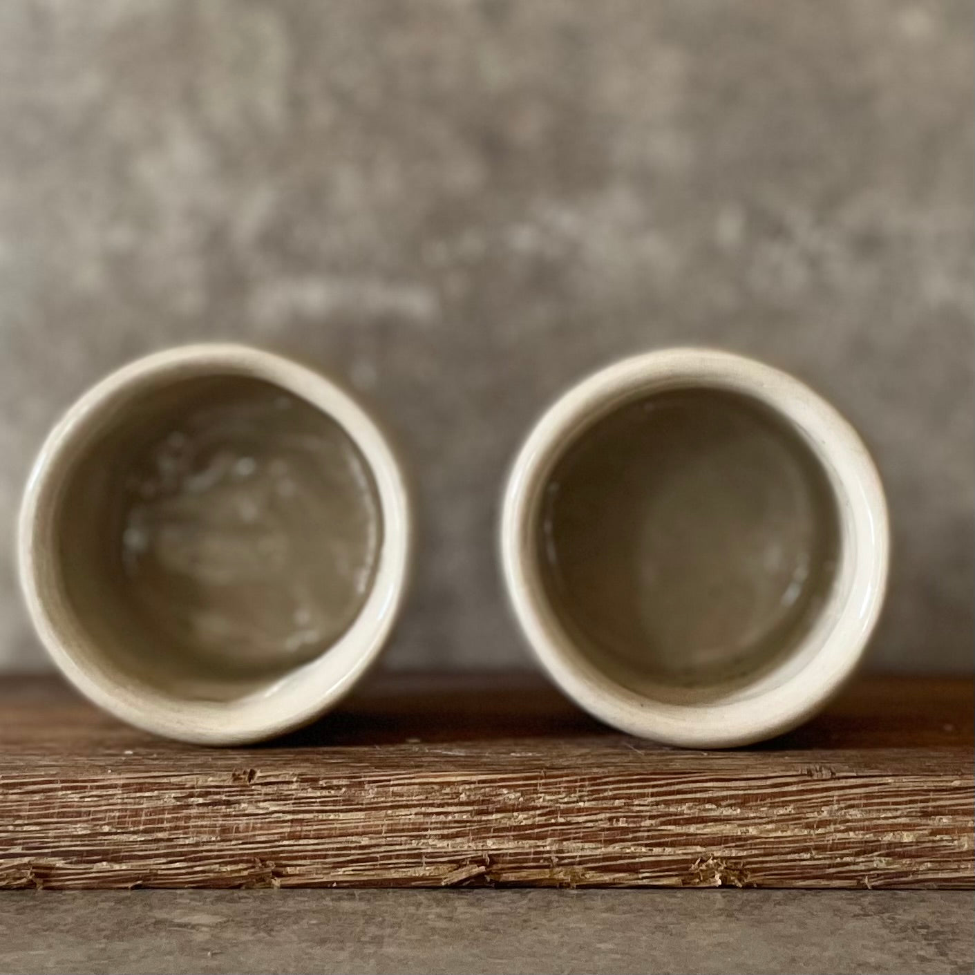A set of small mugs with words in Lithuanian