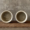 A set of small mugs with words in Lithuanian