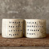 A set of small mugs with words in Lithuanian